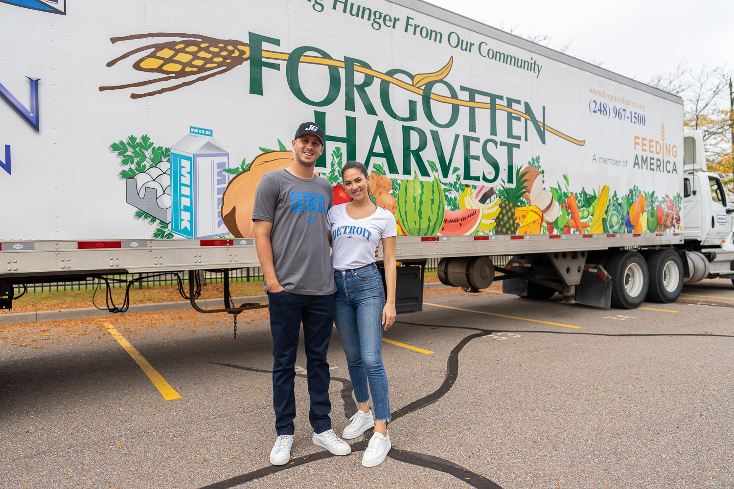 Detroit Lions quarterback Jared Goff and his fiancé, Christen Harper, stand in front of a Forgotten Harvest semi trailer at a food distribution event in Detroit