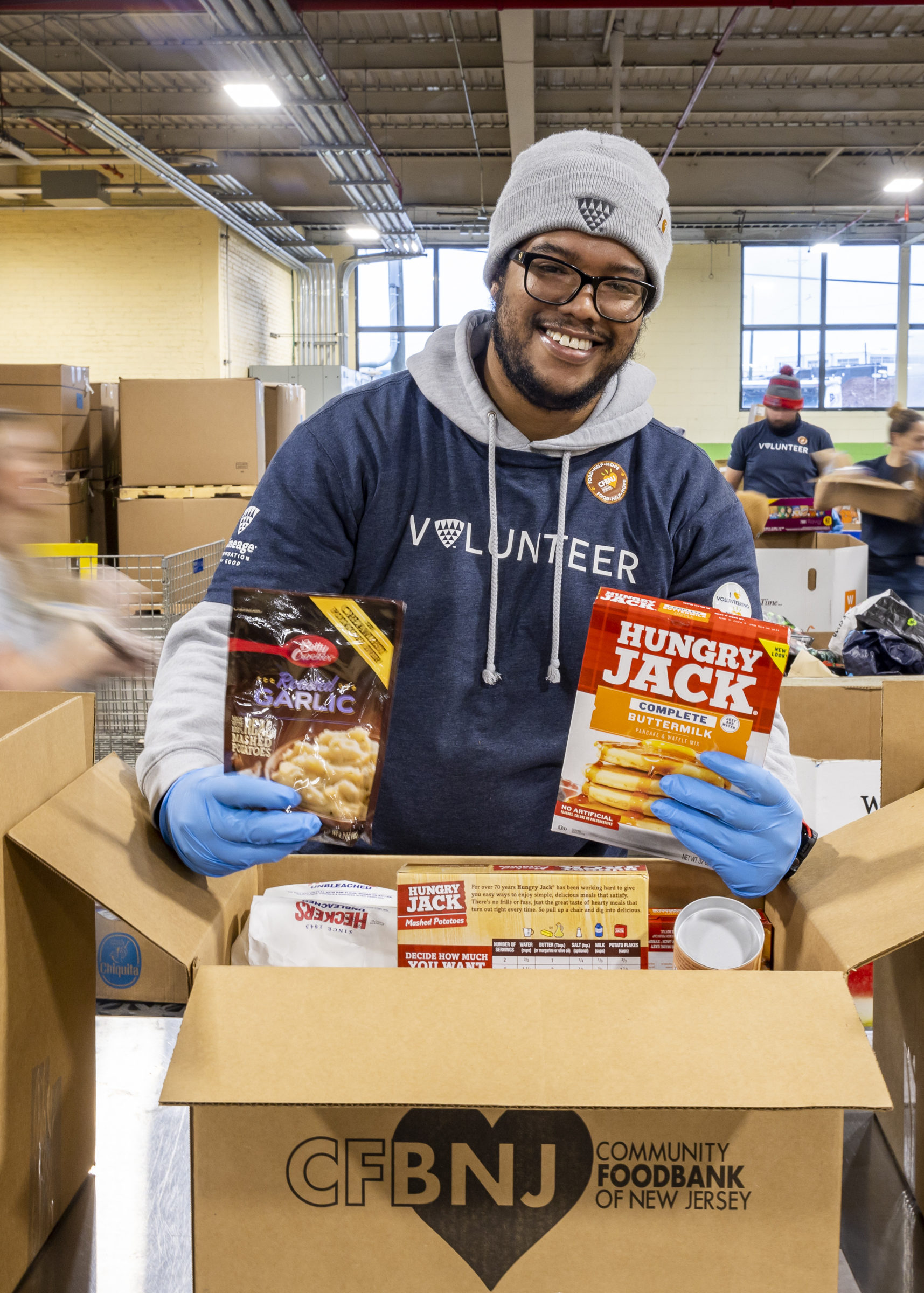 Foundation for Good volunteer packing boxes of food