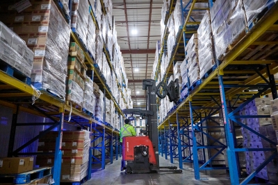 Schnelle Abkühlung in einem Kühlhaus, in dem Gabelstapler Paletten mit Tiefkühlkost durch Hochregallager transportieren, um die Produkttemperaturen rasch zu senken.