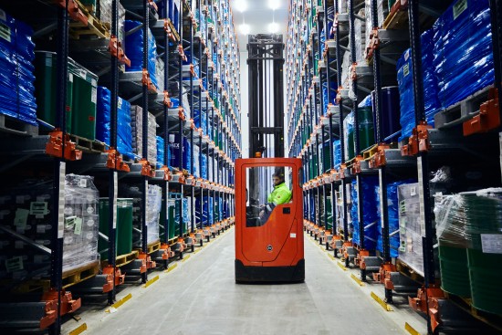 Forklift operator moving palletized products through a high-density cold storage warehouse, supporting efficient inventory management and temperature-controlled food distribution.