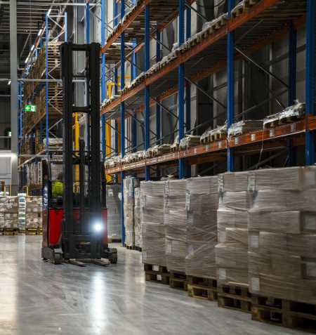 Ein Lineage arbeitet in einem Kühlhaus in Bremerhaven und transportiert mit einem Gabelstapler Paletten mit Tiefkühlkost innerhalb des Lagers.