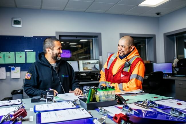 Two Lineage team members reviewing shipping documents and customs paperwork in an office setting, helping ensure regulatory compliance