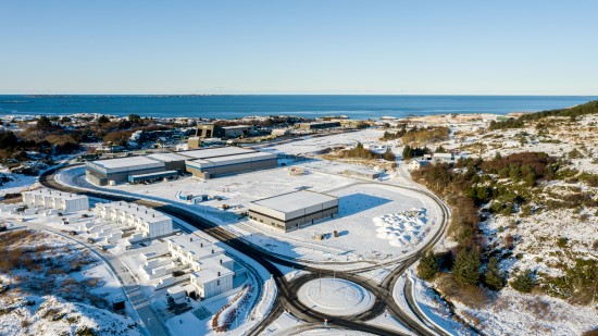 Luftaufnahme des Kühlhauses Lineage in Haugesund, Norwegen, mit mehreren temperaturgeregelten Lagerhallen in Küstennähe und der umgebenden verschneiten Landschaft.