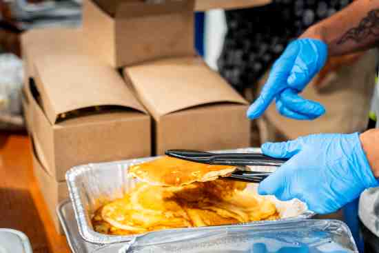 A Lineage volunteer helps distribute food at an event