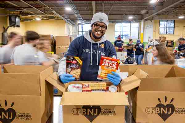 A Lineage volunteer packs food at a food bank