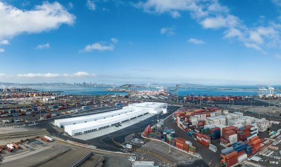 Panoramic view of a large port facility with shipping containers, warehouses, and cranes along the waterfront, showcasing Lineage’s port-centric infrastructure.