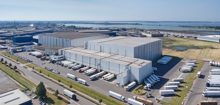 Aerial view of Lineage’s Bergen op Zoom, Netherlands cold storage facility in the Netherlands, featuring multiple loading bays and refrigerated trucks for drayage and distribution.