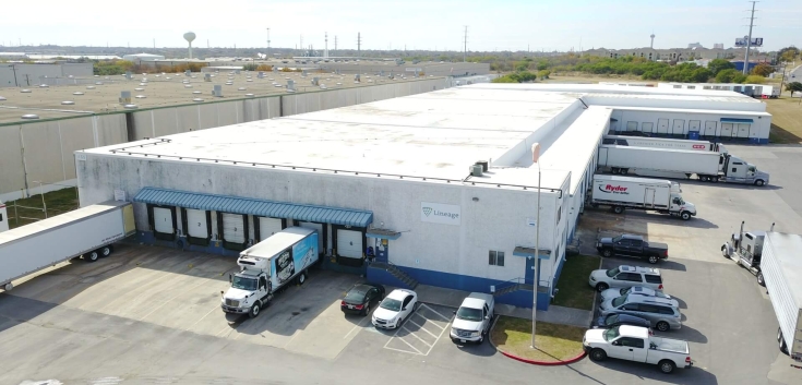 Aerial view of Lineage’s San Antonio Frost Bank Center facility, showing the white warehouse, loading docks, trailers and parked vehicles on a clear day.