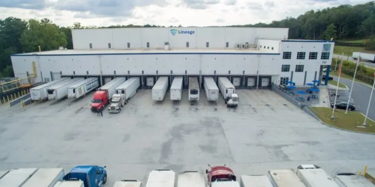 Vorderansicht des Kühlhauses Lineagein Lithia Springs, Atlanta, mit mehreren Lkw, die an den Laderampen angedockt sind, was die logistischen Kapazitäten des Unternehmens unterstreicht.