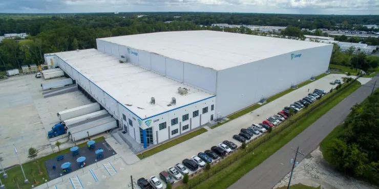 Aerial side view of Lineage’s Doolittle facility in Jacksonville, showcasing expansive warehouse space, loading docks and a well-maintained parking area.