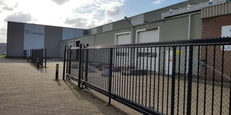 Exterior view of Lineage’s cold storage facility in Hoogerheide, Netherlands, featuring secure gated access and loading dock bays.