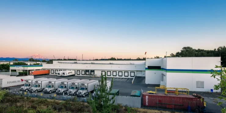 Foto dell'esterno dello stabilimento Lineage a Tacoma al tramonto, con il Monte Rainier sullo sfondo