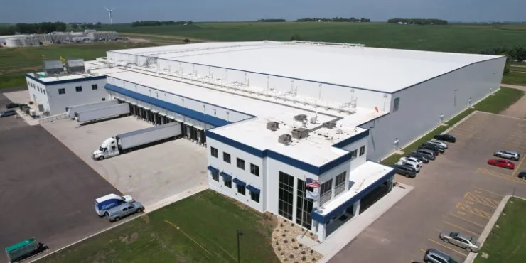 Vista aerea del magazzino frigorifero Lineage a Luverne, nel Minnesota: una struttura moderna dotata di numerose banchine di carico, con camion in sosta e terreni agricoli circostanti, a garanzia dell'efficienza della catena del freddo.