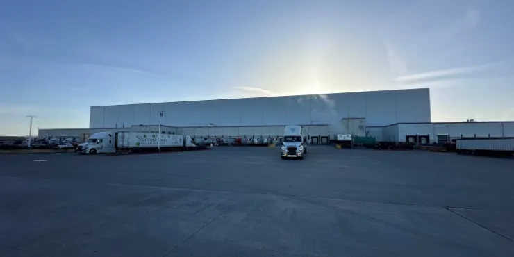 Ammirate l'ampia veduta del magazzino frigorifero Lineage a Pasco, nello Stato di Washington, con le banchine di carico, i camion parcheggiati e un vasto piazzale asfaltato all'alba, a testimonianza della sua vasta capacità logistica.
