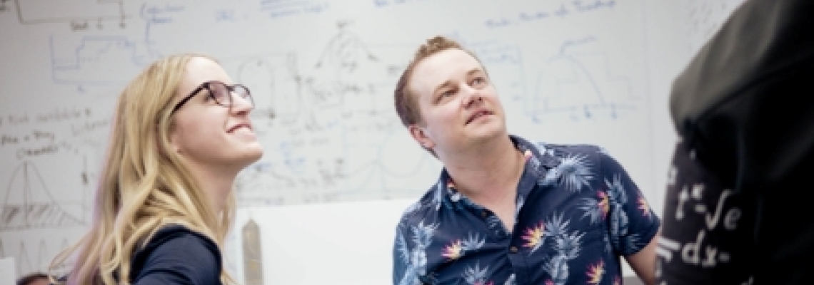 Lineage data science team analyzing supply chain models on a whiteboard during a network optimization session.