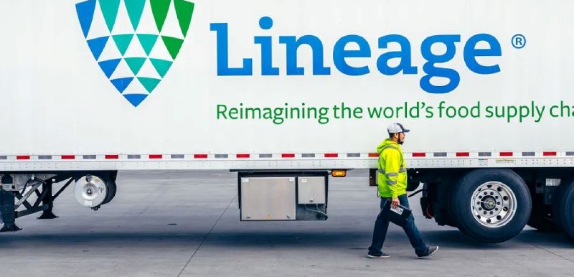 Lineage refrigerated trailer parked at a warehouse with an employee walking beside it, highlighting temperature-controlled transportation and logistics operations.
