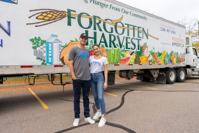 Jared Goff, Quarterback der Detroit Lions, und seine Verlobte Christen Harper stehen bei einer Lebensmittelspendenaktion zugunsten der Einwohner Detroits vor einem Sattelauflieger von „Forgotten Harvest“
