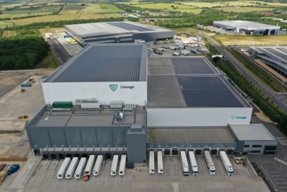 Aerial view of a large Lineage automated cold storage facility with solar panels and multiple loading docks, highlighting sustainable design and high-volume distribution capability.