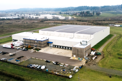 An aerial view of Lineage's cold storage warehouse in Salem, OR shows the building has solar panels on the roof