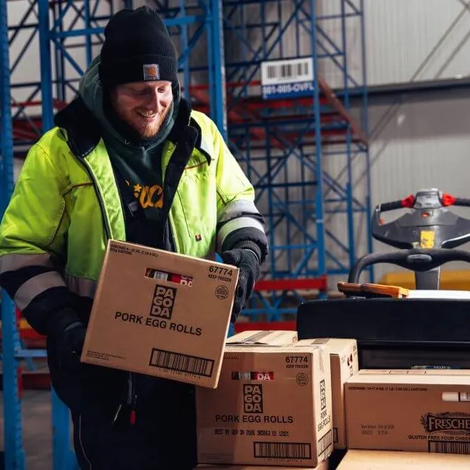 Lineage team member in a freezer carefully case picking product for a supply chain customer.