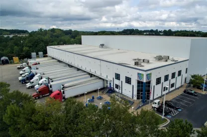 Exterior view of Lineage’s College Park cold storage facility in Atlanta, showcasing a modern warehouse design with multiple loading docks and ample truck parking.