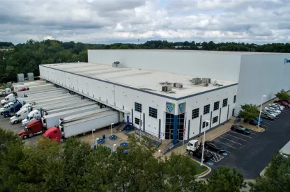 Exterior view of Lineage’s College Park cold storage facility in Atlanta, showcasing a modern warehouse design with multiple loading docks and ample truck parking.