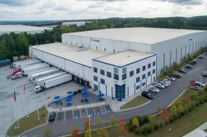 Exterior view of Lineage’s Lithia Springs cold storage facility in Atlanta, showcasing a modern warehouse design with multiple loading docks and parking areas.