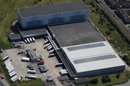 Aerial view of Lineage’s Grimsby cold storage and port facility in the UK, featuring loading bays, solar panels and refrigerated trailers.