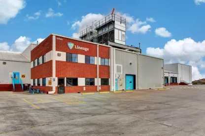 Exterior of the Lineage cold storage facility in El Paso, Texas, showing the brick office building, warehouse bays and paved lot under a clear sky.
