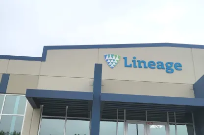 Front entrance of Lineage’s Lancaster, Texas facility, showing the blue-accented building facade, logo signage and glass entryway on an overcast day.